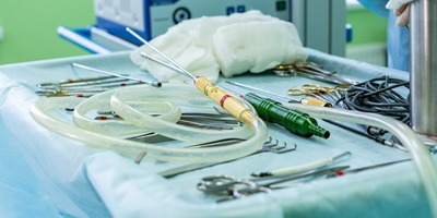 Liposuction vs.tummy tuck. Liposuction canals and suction tubing on the operating room table ready for surgery